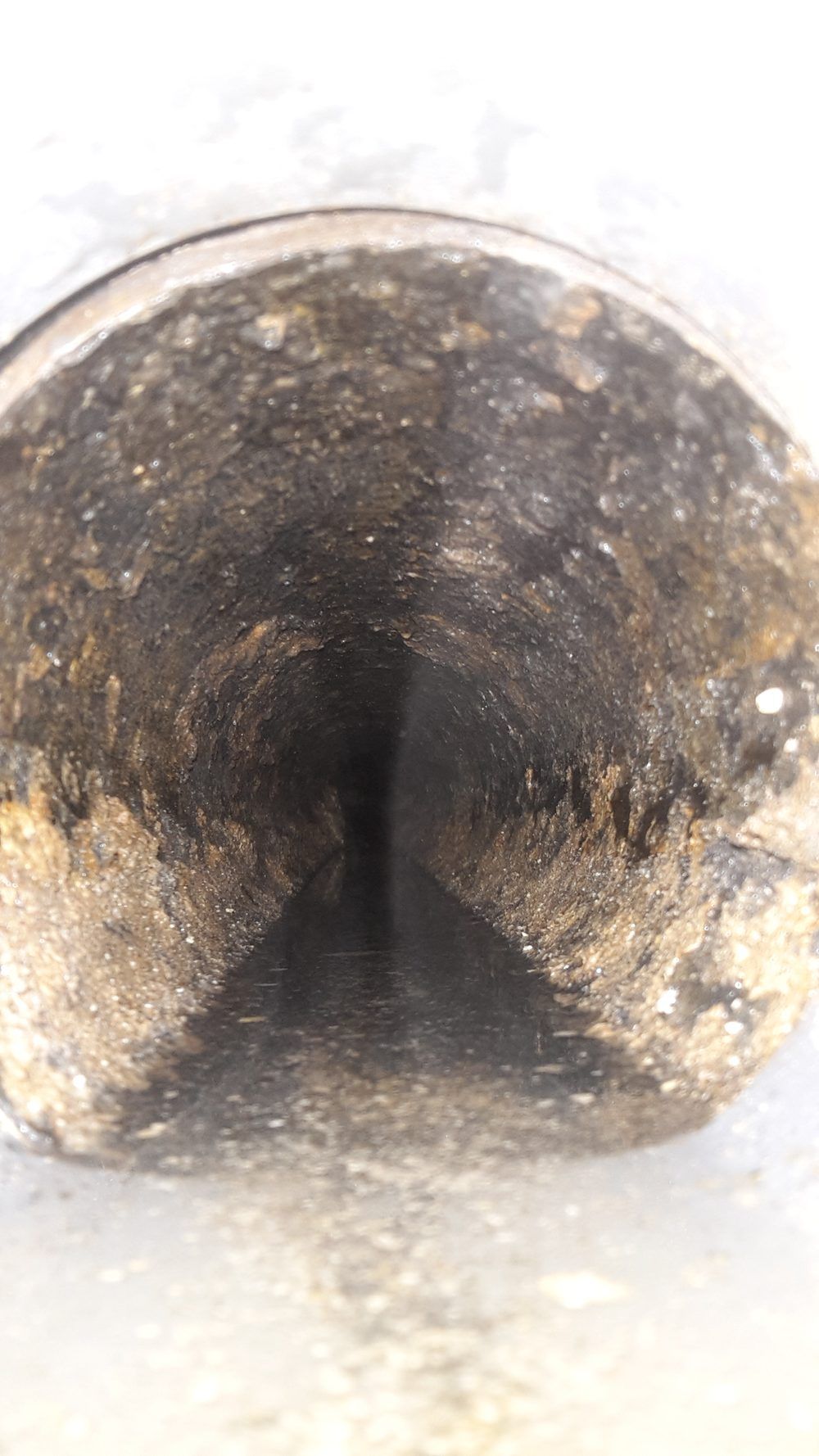 Insidan av ett köksavloppsrör som är rensat, med fri passage nästan hela rörets diameter.